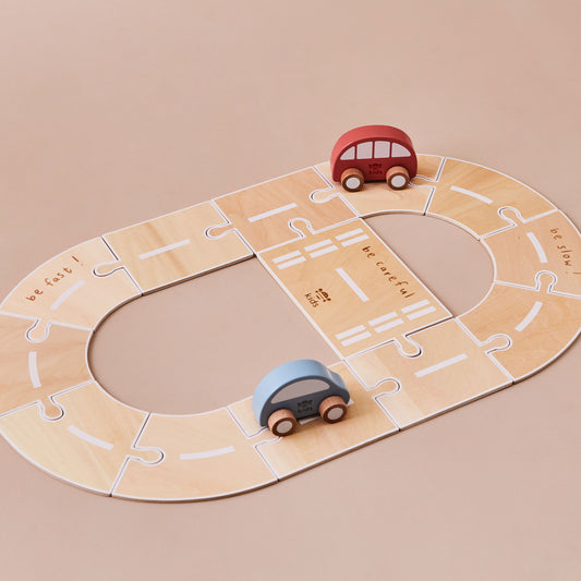 Wooden toy road with two cars on a beige background