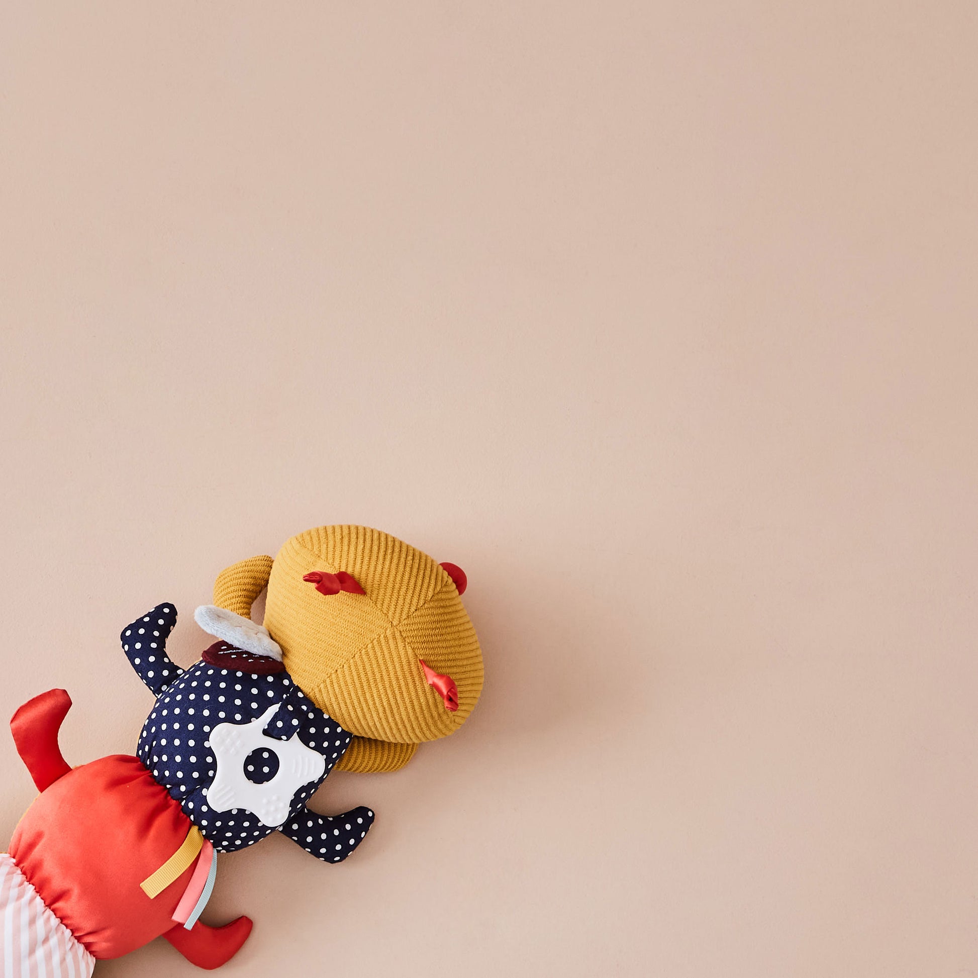 Colourful plush toy caterpillar on a beige background