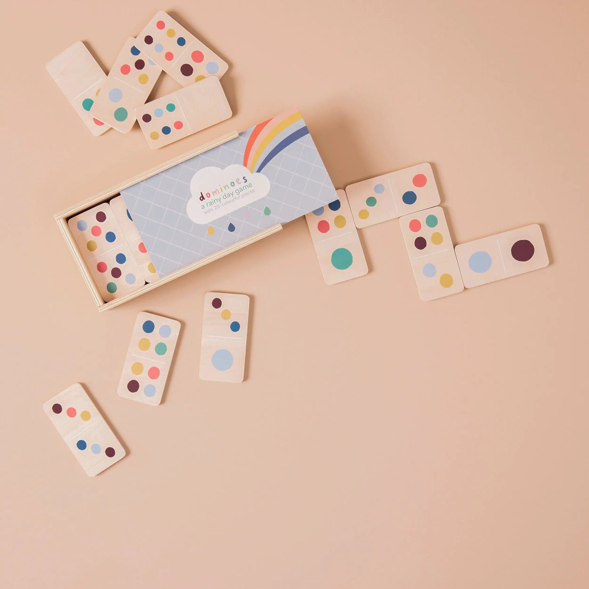Wooden dominoes with colourful dots on a beige background