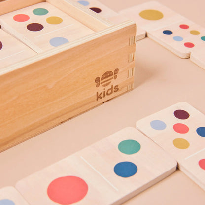 Colourful dot wooden toys with a 'just bee kids' branded box on a beige surface