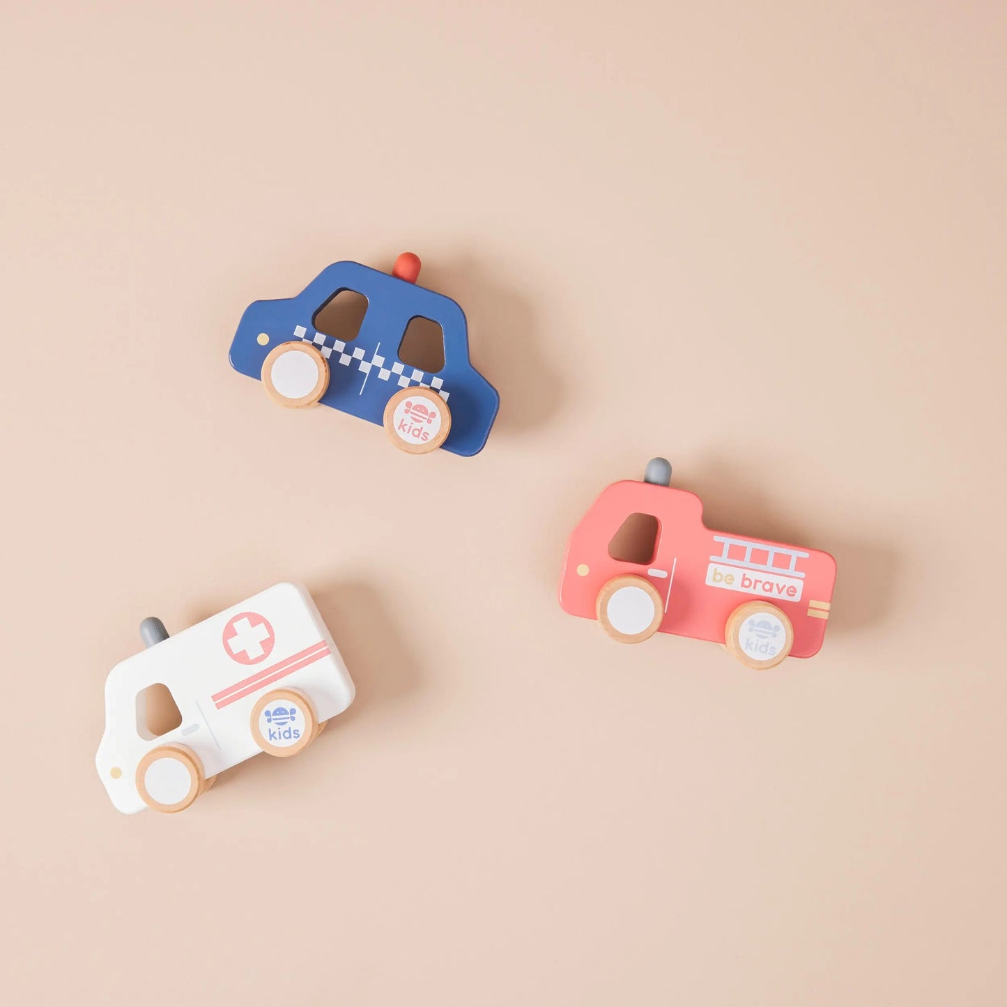 Three wooden toy vehicles on a beige background