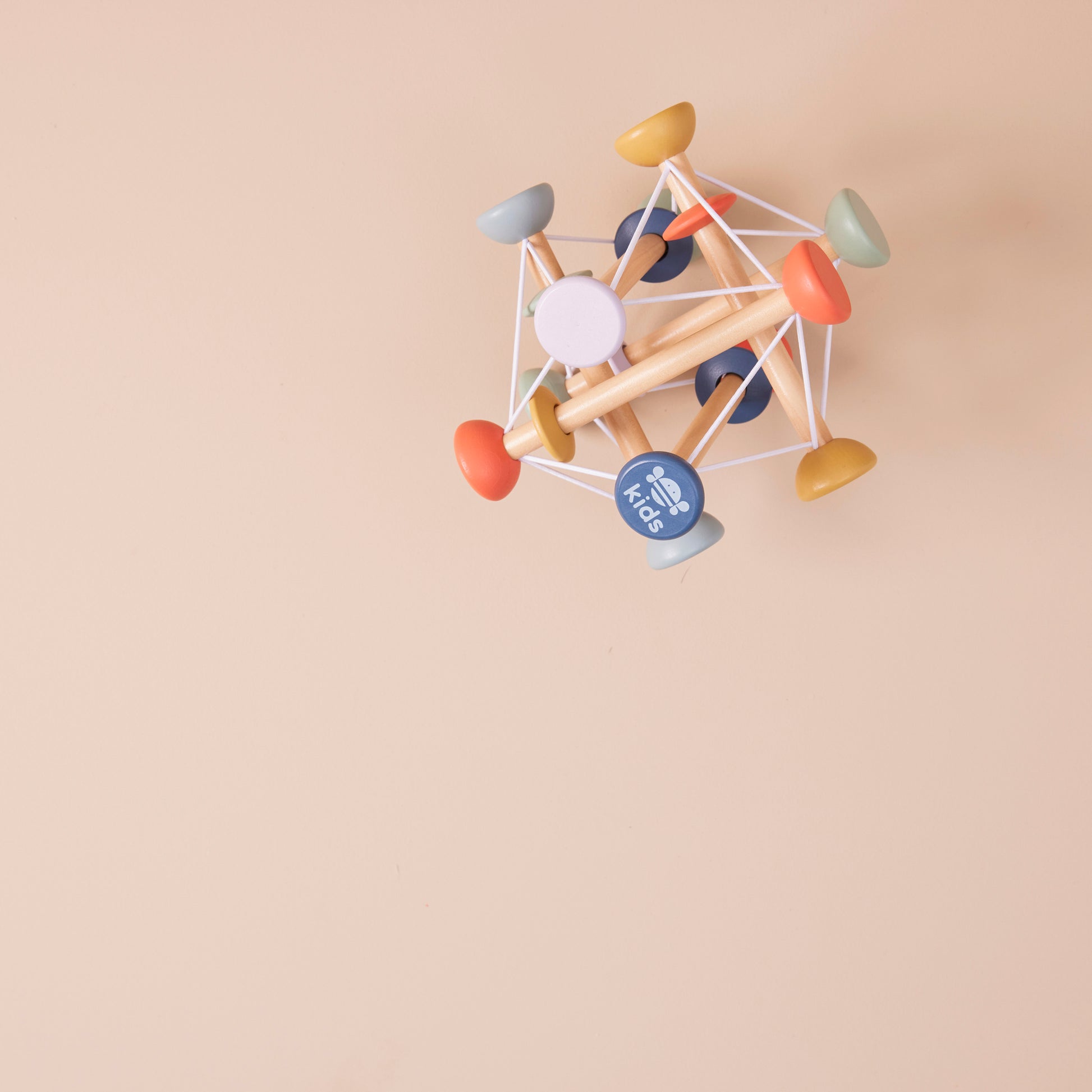 Colourful geometric wooden activity toy on a beige background