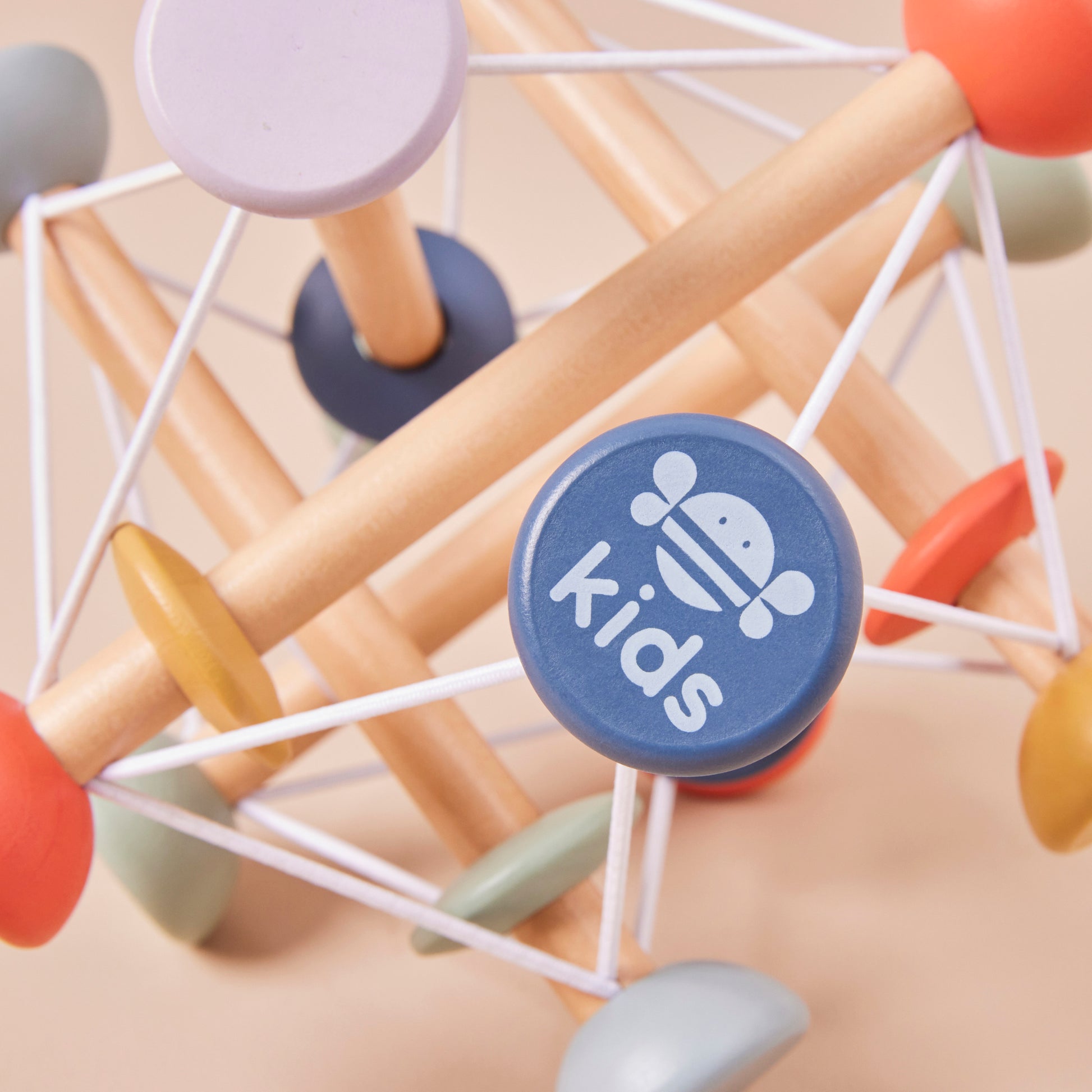 Colourful geometric wooden activity toy with a 'kids' logo on a beige background
