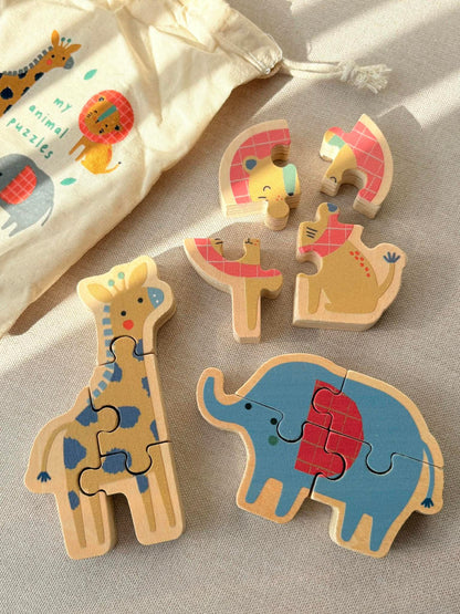 Wooden animal puzzles including a giraffe and an elephant on a fabric background.