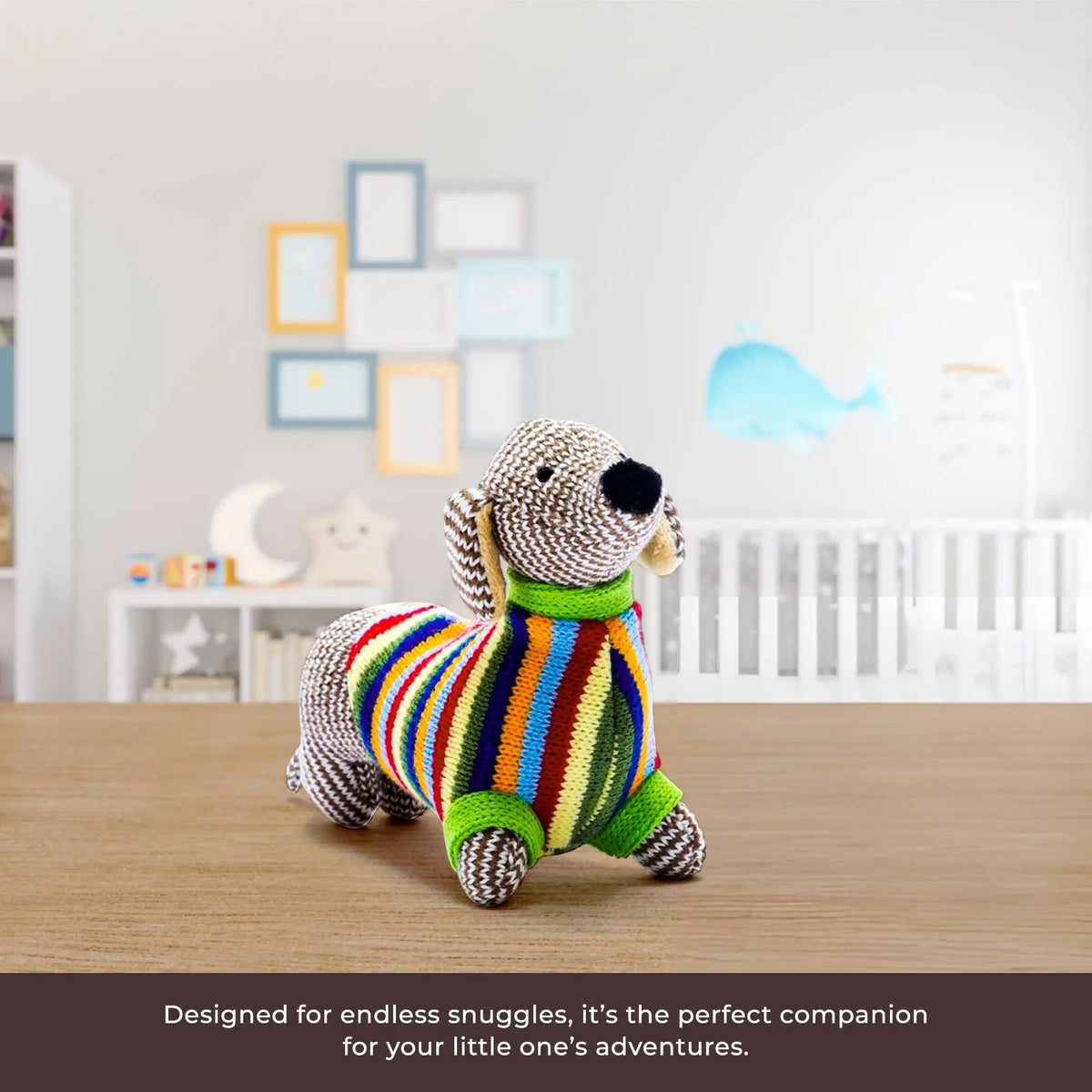 Colourful stuffed dog toy on a wooden floor with a baby crib and toys in the background.