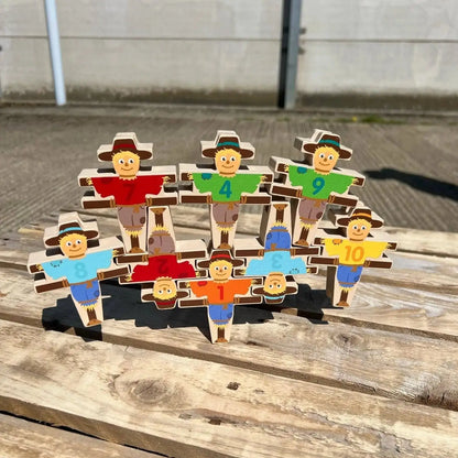 Set of wooden figures with different coloured shirts on a wooden surface.