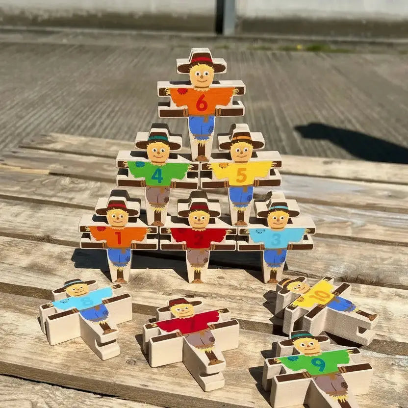 Wooden block tower with colourful figures on a wooden surface