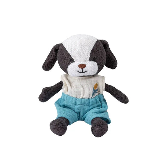 Stuffed toy dog with a white face, black ears, and blue shorts on a white background