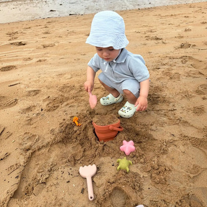 Toddler using beach set in sand