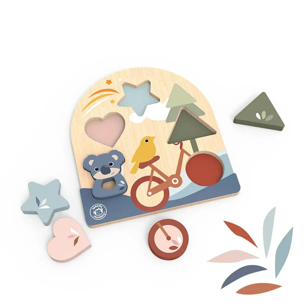 A wooden children's puzzle board with colourful cutout shapes and pieces, including a bicycle, bear, bird, trees, and abstract leaf shapes, photographed on a clean white background.