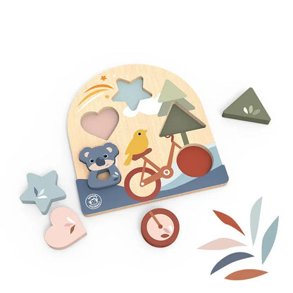 A wooden children's puzzle board with colourful cutout shapes and pieces, including a bicycle, bear, bird, trees, and abstract leaf shapes, photographed on a clean white background.