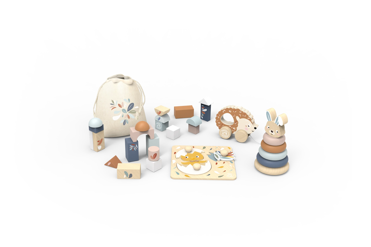 A wooden baby play set with a cream-colored drawstring bag, wooden blocks, a teething ring, a stacking ring toy, and a rabbit figure, arranged on a clean white background.