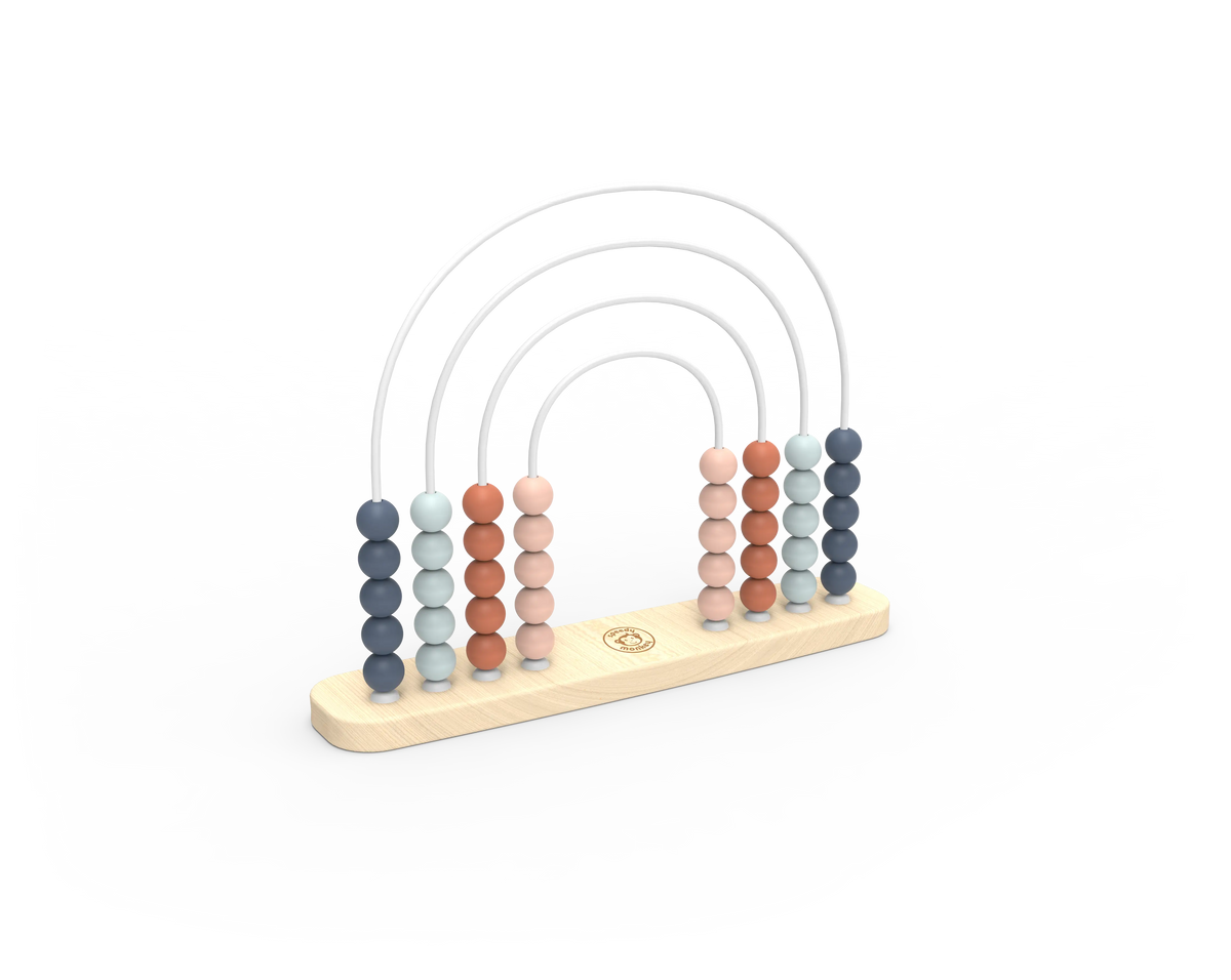 A wooden abacus with five vertical columns of round beads in muted blue, peach, and terracotta tones, suspended by thin white arches on a light natural wood base. A small circular logo is visible in the center of the base.