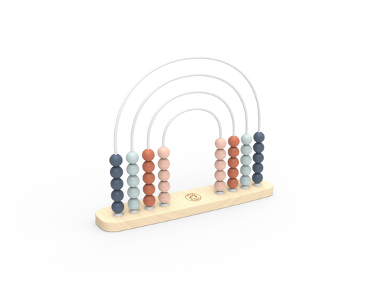 A wooden abacus with five vertical columns of round beads in muted blue, peach, and terracotta tones, suspended by thin white arches on a light natural wood base. A small circular logo is visible in the center of the base.
