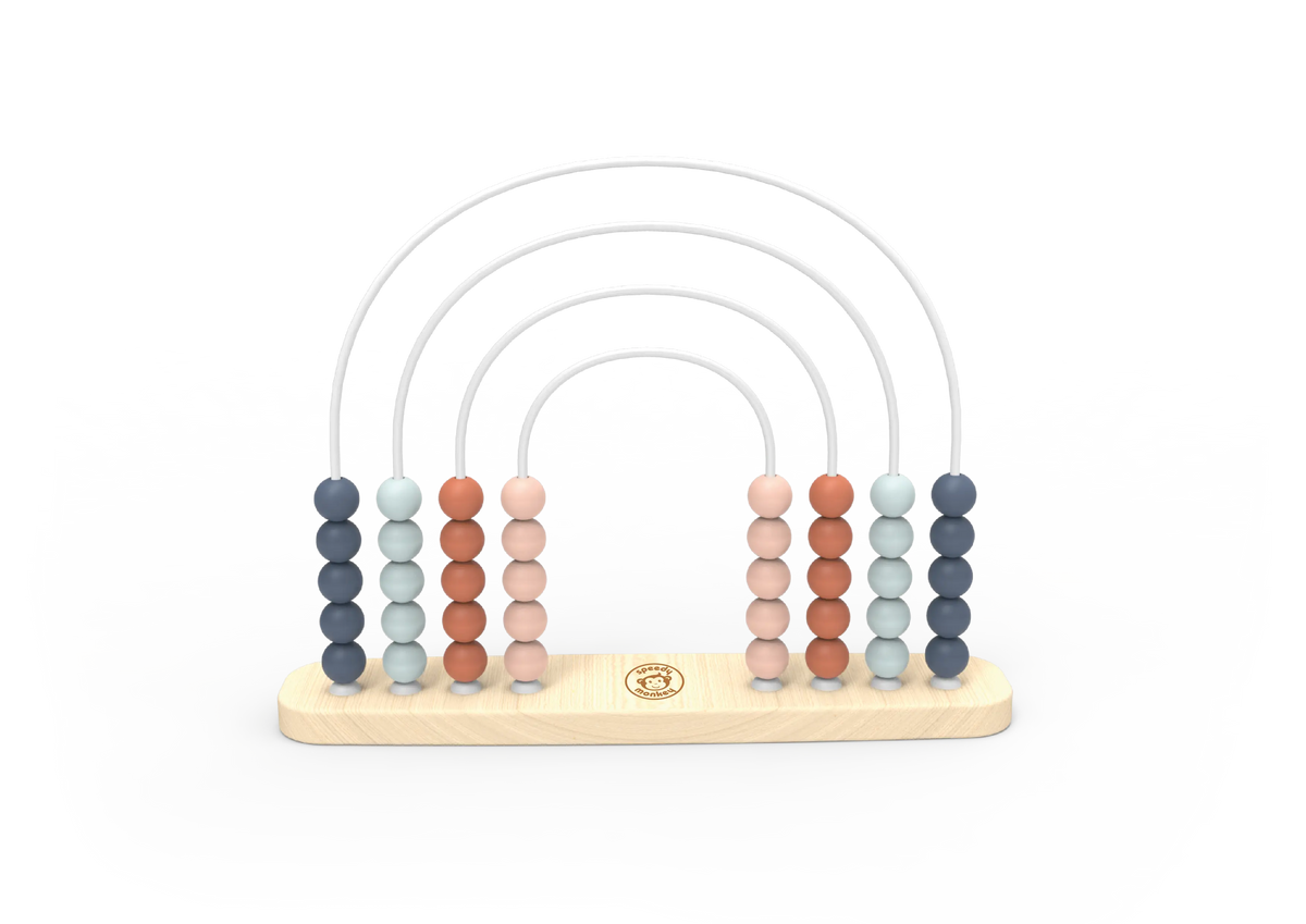 A wooden arch bead toy with six vertical columns of round beads in muted blue, pale green, terracotta, peach, and light grey, suspended over a light natural wood base with a small gold circular logo in the centre.