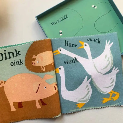 Children's cloth books with animal illustrations on a white surface