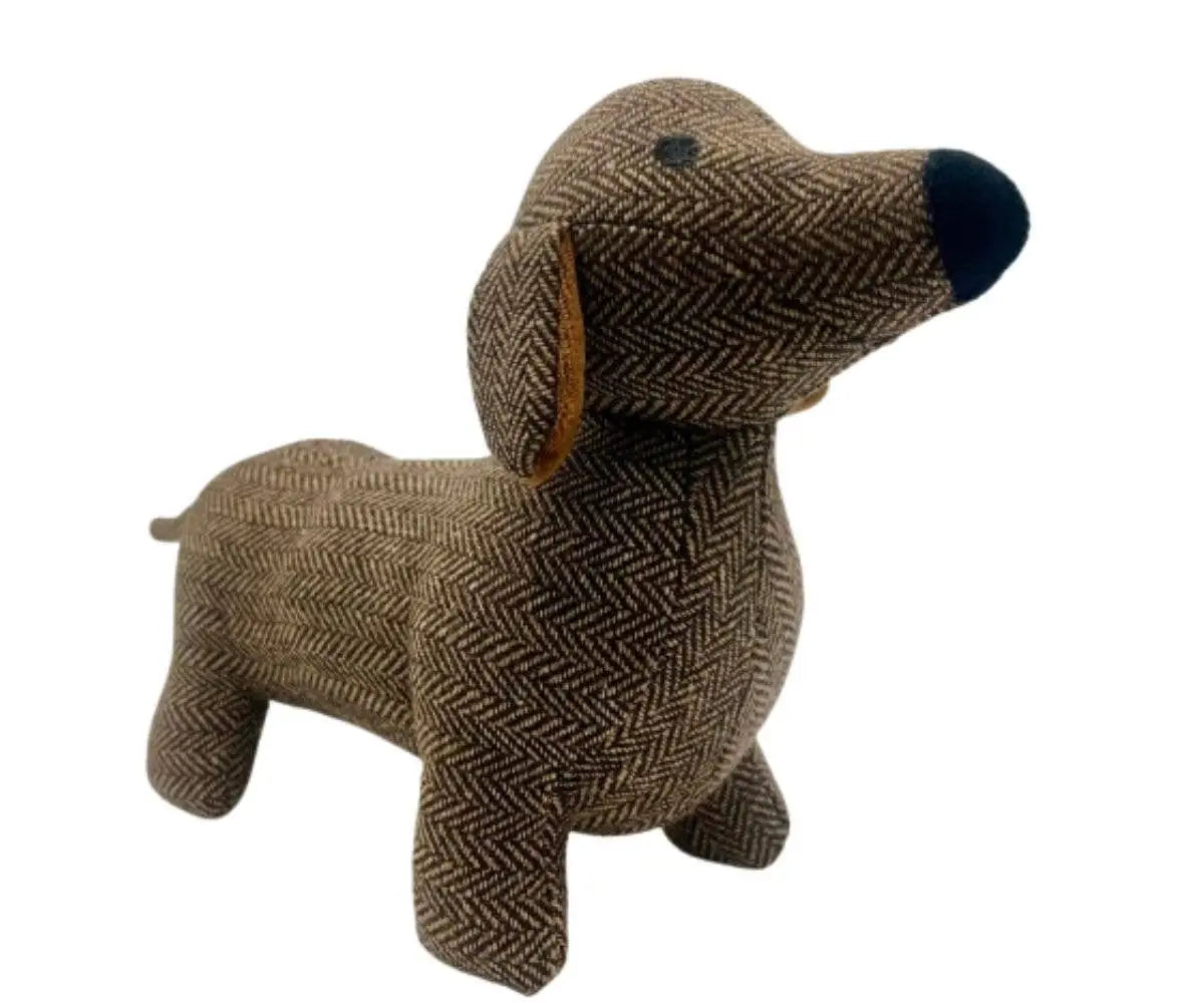 A dachshund-shaped plush toy or stuffed dog made from brown and beige herringbone tweed fabric, with a dark navy nose and small black eyes, shown on a plain white background.
