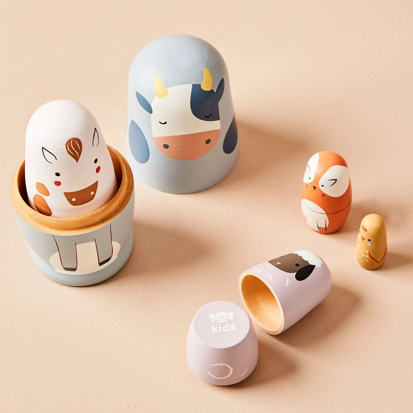 Set of wooden toys shaped like animals on a beige background