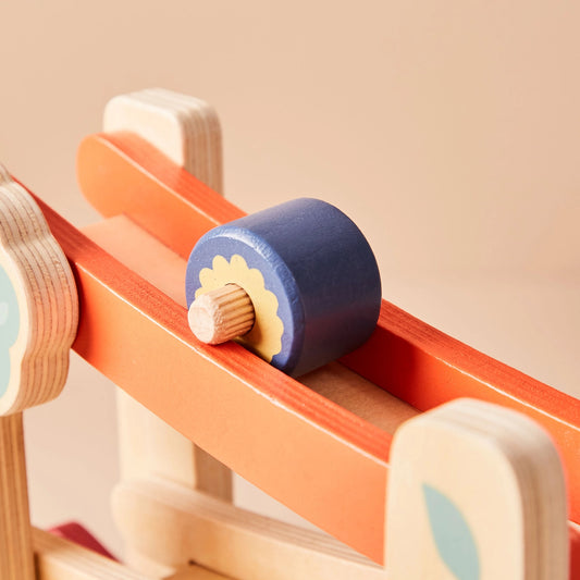 Close-up of a wooden toy with a blue roller on a beige background