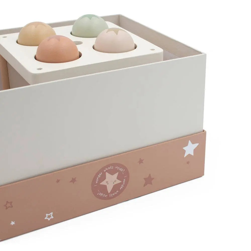 Box with pastel-coloured balls and star pattern on a white background