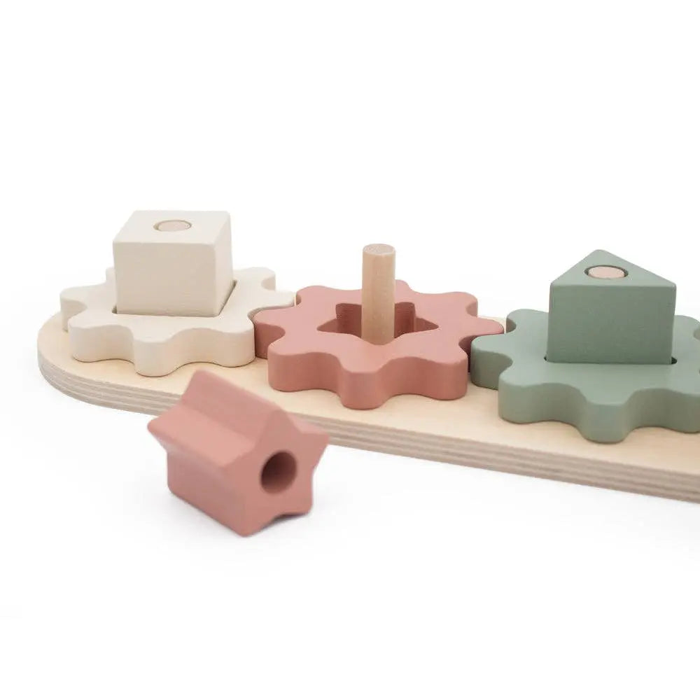 Wooden shape sorter toy with pastel-coloured shapes on a white background