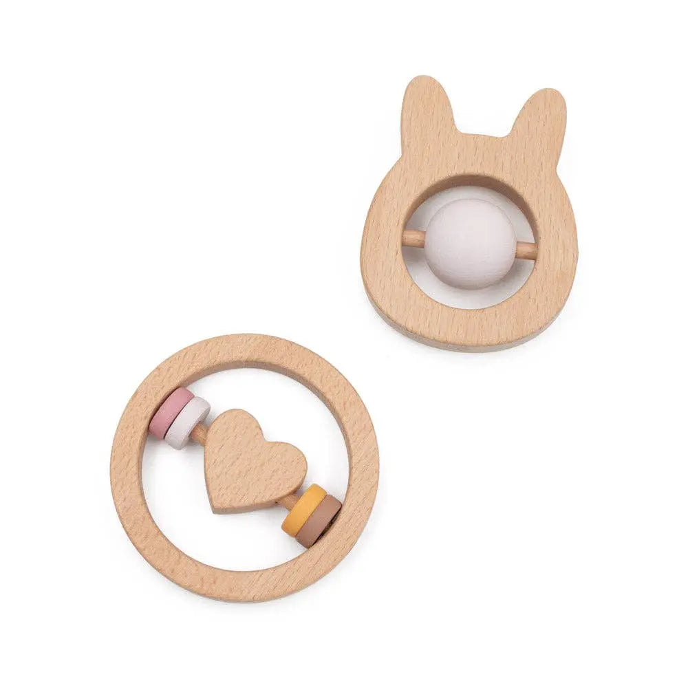Two wooden baby rattles with bunny and circular designs on a white background