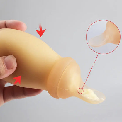 Close-up of a baby bottle with a squeezable silicone body and spoon-shaped teat for easy self-feeding.