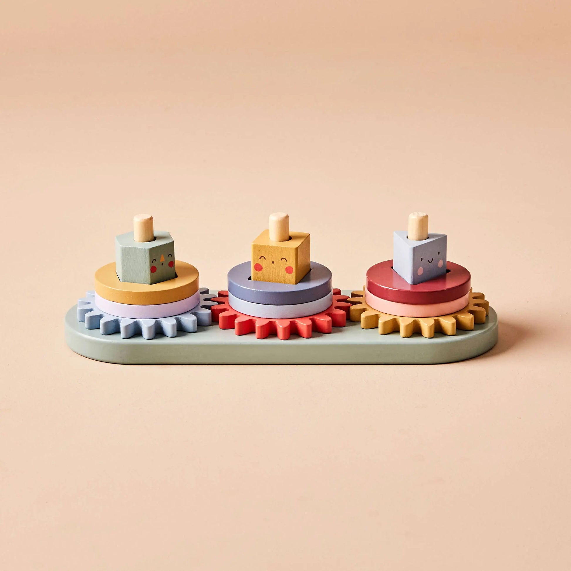 Coloruful wooden toy with geometric shapes and gears on a beige background
