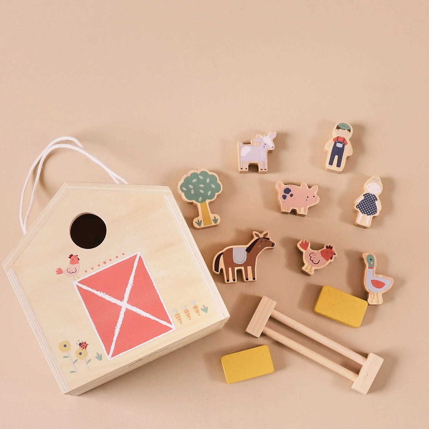 Set of wooden toys including a birdhouse and various animal figures on a beige background