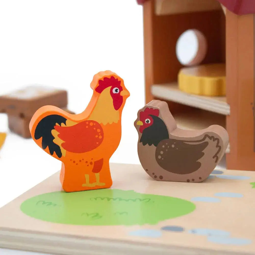 Wooden rooster and hen toys on a farm-themed board with a blurred background.
