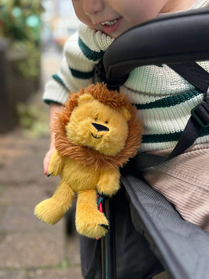 Child looking at a plush lion toy in a buggy