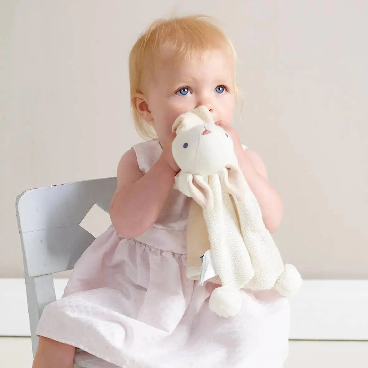Child holding a plush toy in a softly lit room