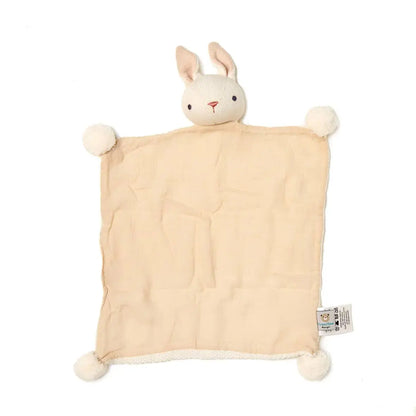 Beige blanket with bunny head and pom-pom ears on a white background