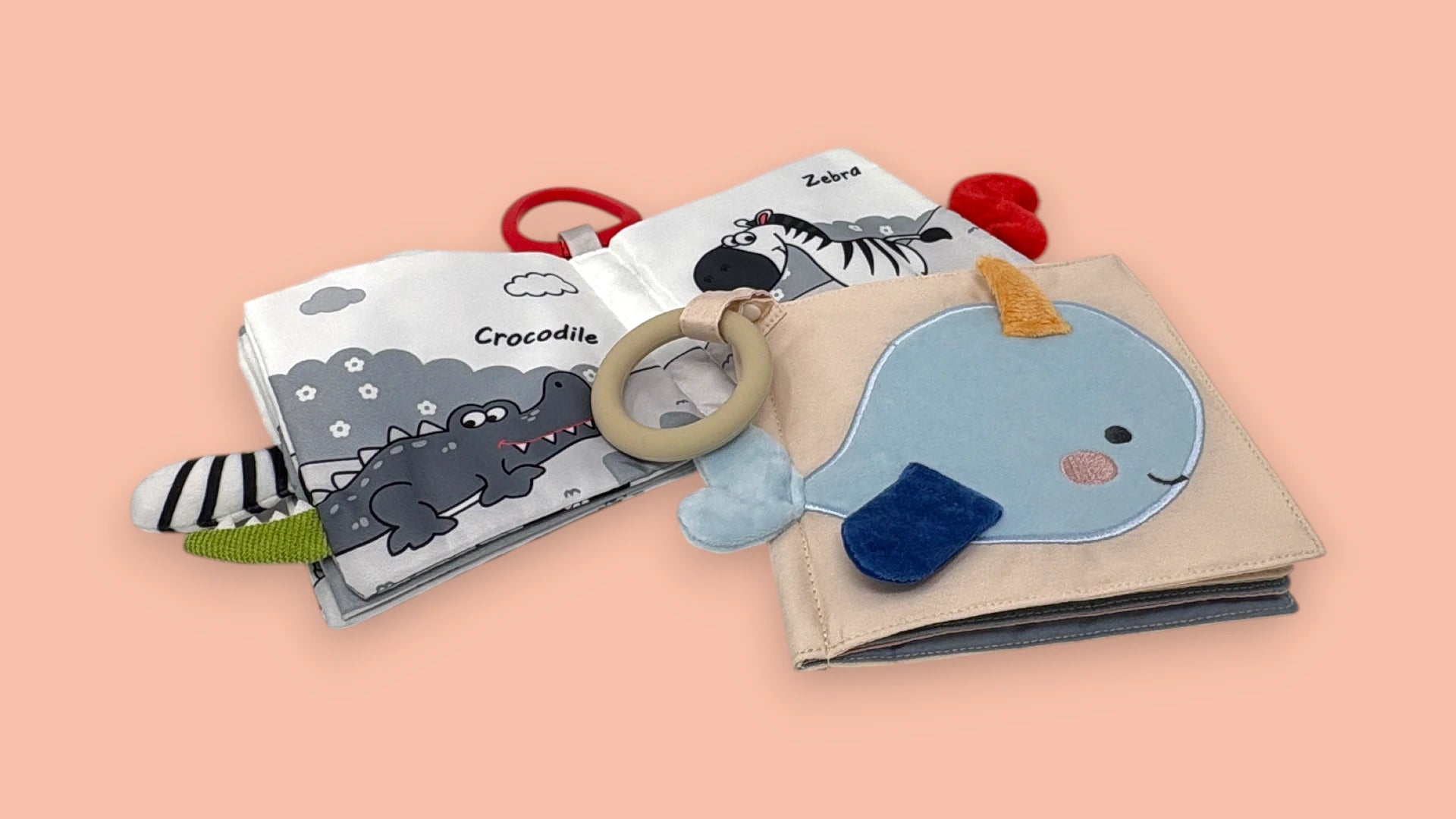 Children's soft crinkle books with animal illustrations and plush covers on a pink background