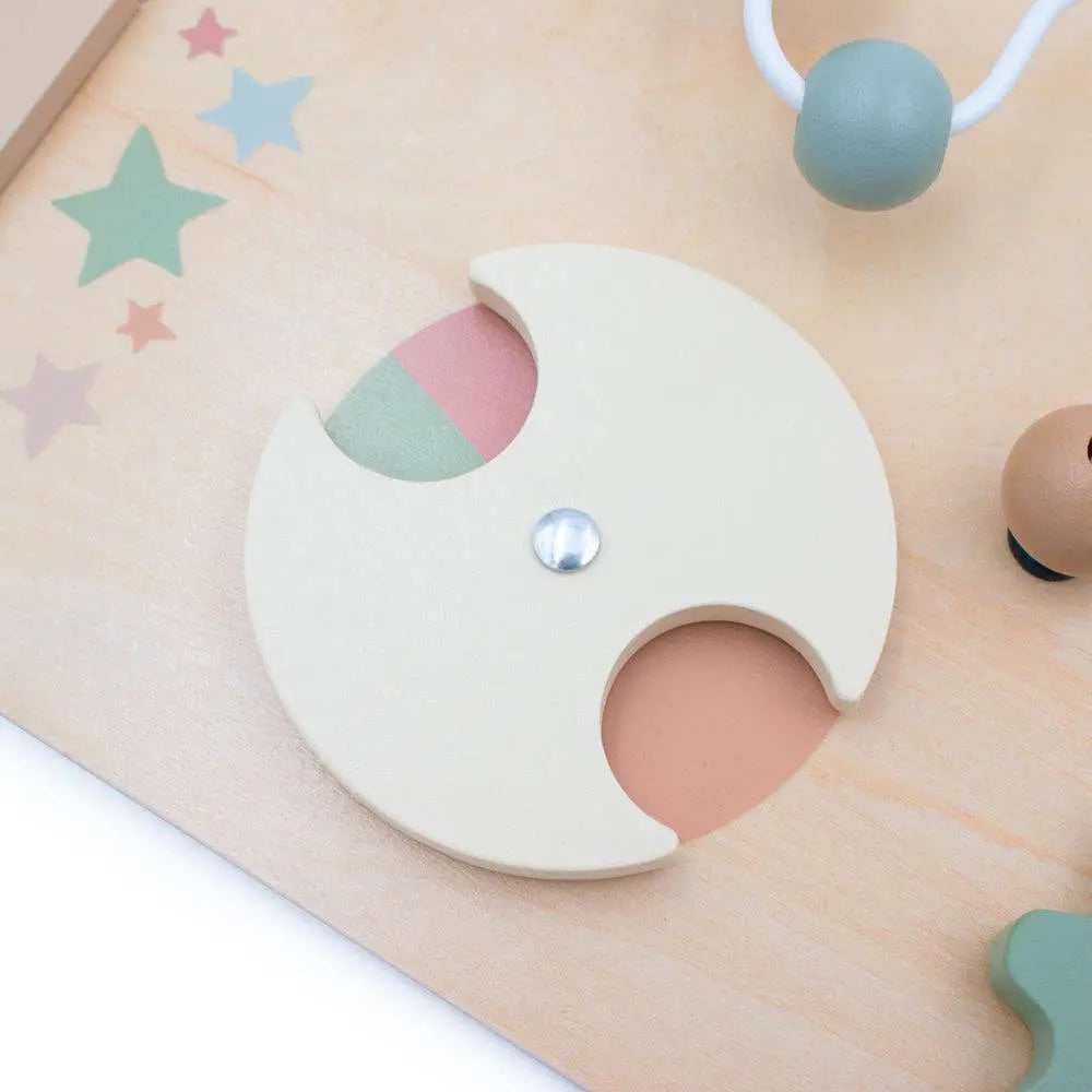 Wooden baby teether with pastel colours on a wooden surface