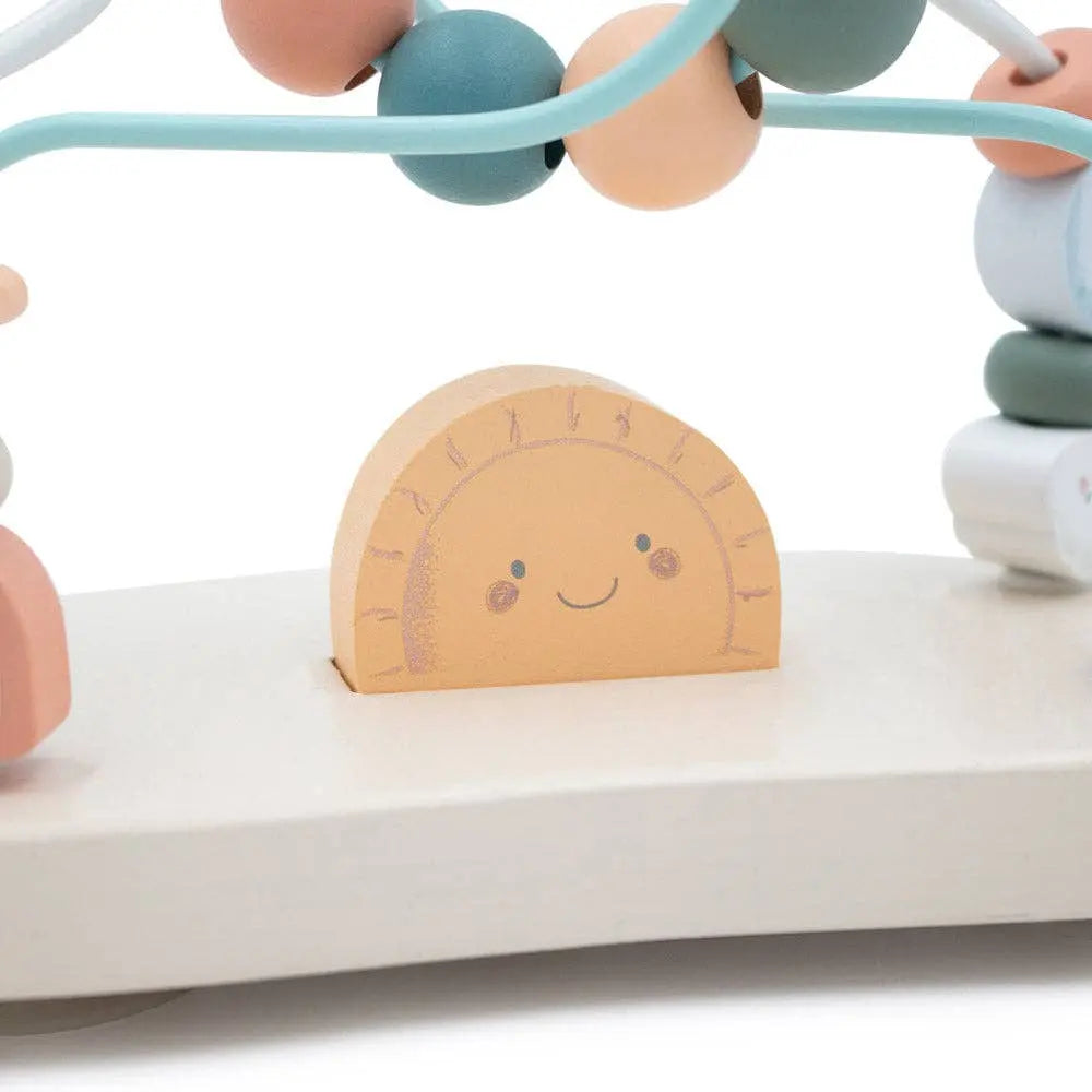 Children's toy with colourful beads and a wooden clock on a white surface