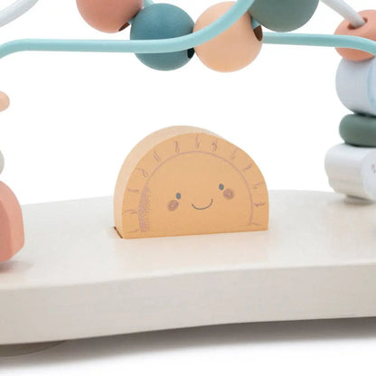 Children's toy with colourful beads and a wooden clock on a white surface