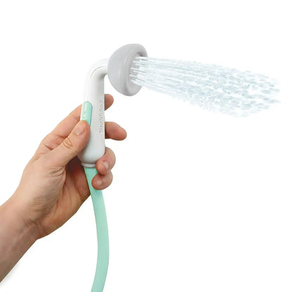 Hand holding a shower head with water spraying out on a white background
