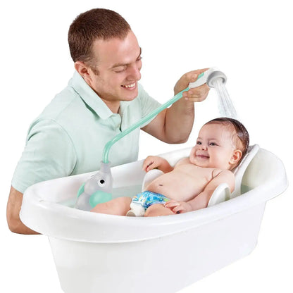 Man bathing a baby in a white bathtub with a green shower head attachment.