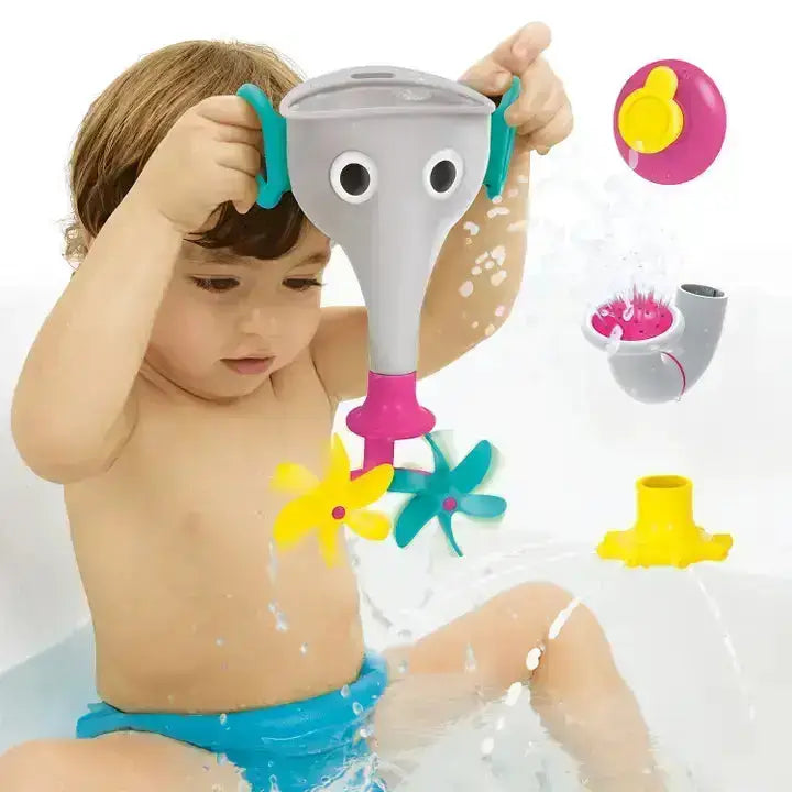 Child playing with a bathtub toy featuring a face and various attachments.