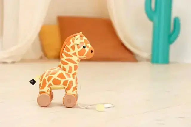 Toy giraffe with wheels on a light surface