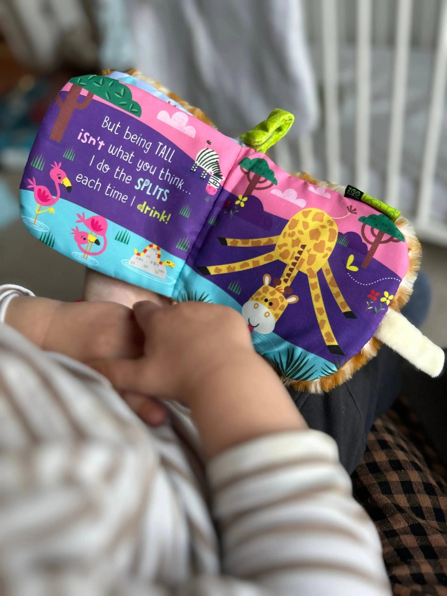 Child holding a colourful children's book with animal illustrations.