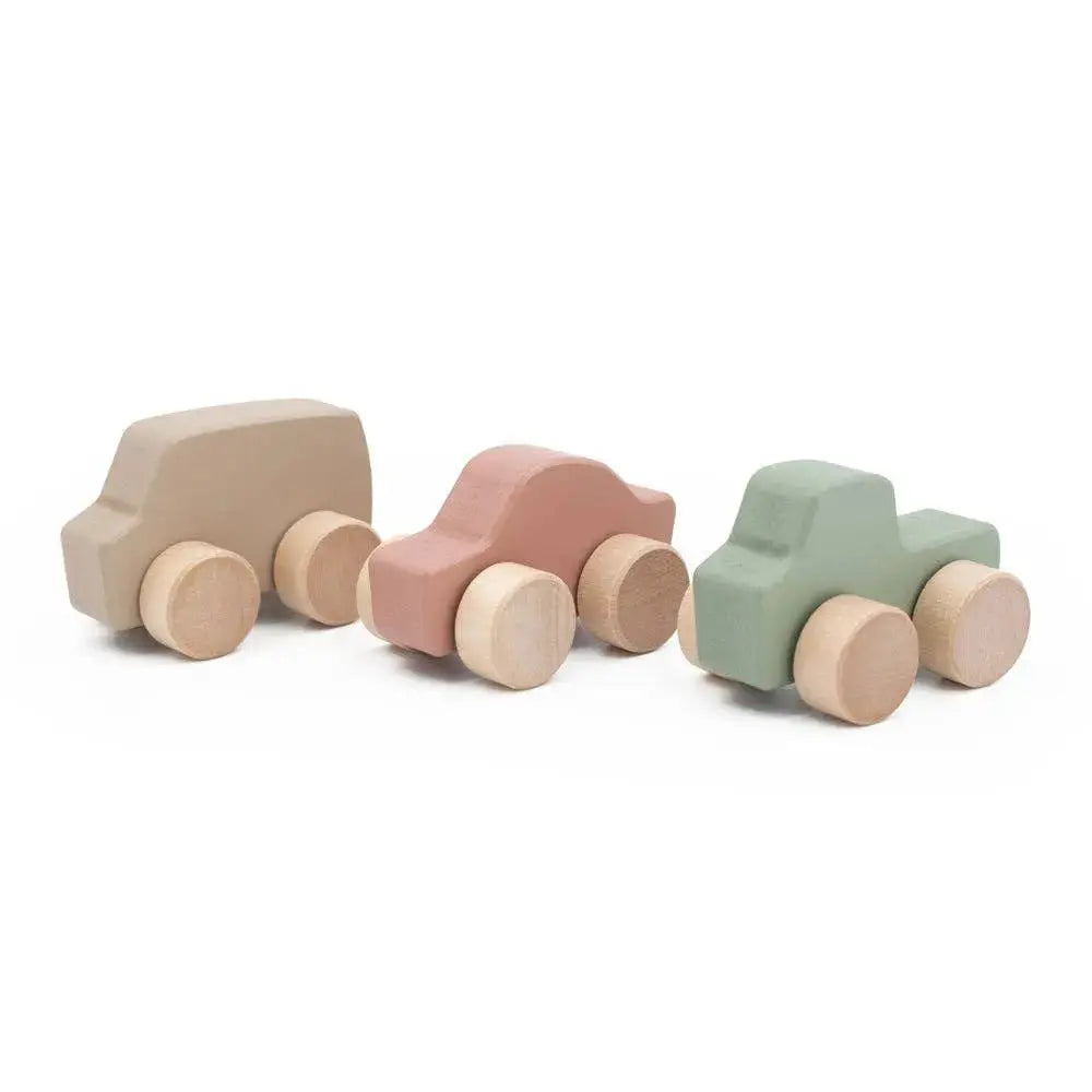 Set of three pastel-coloured wooden toy cars on a white background