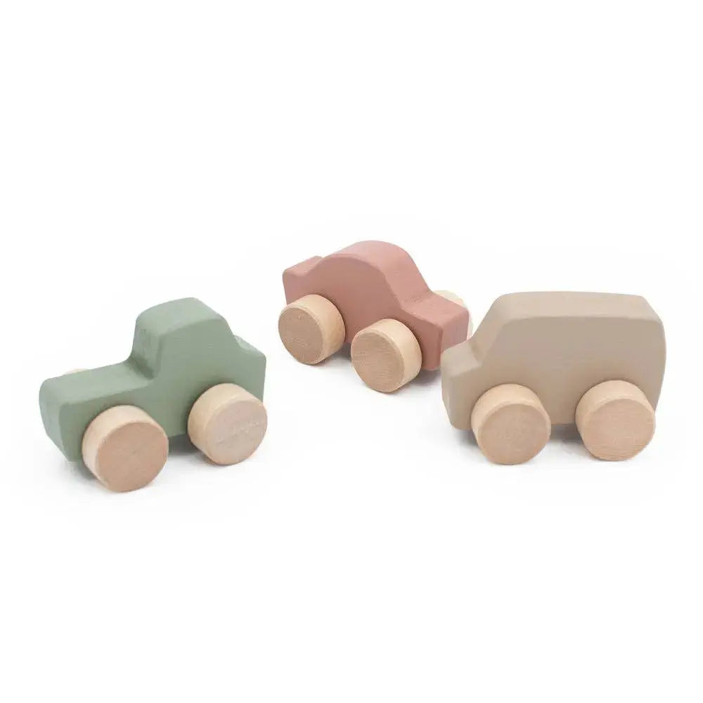 Set of three wooden toy cars in pastel colours on a white background