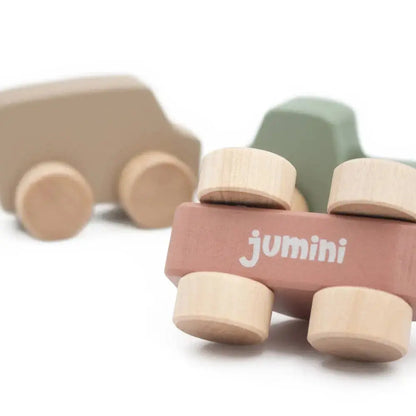 Wooden toy cars with 'jumini' branding on a white background