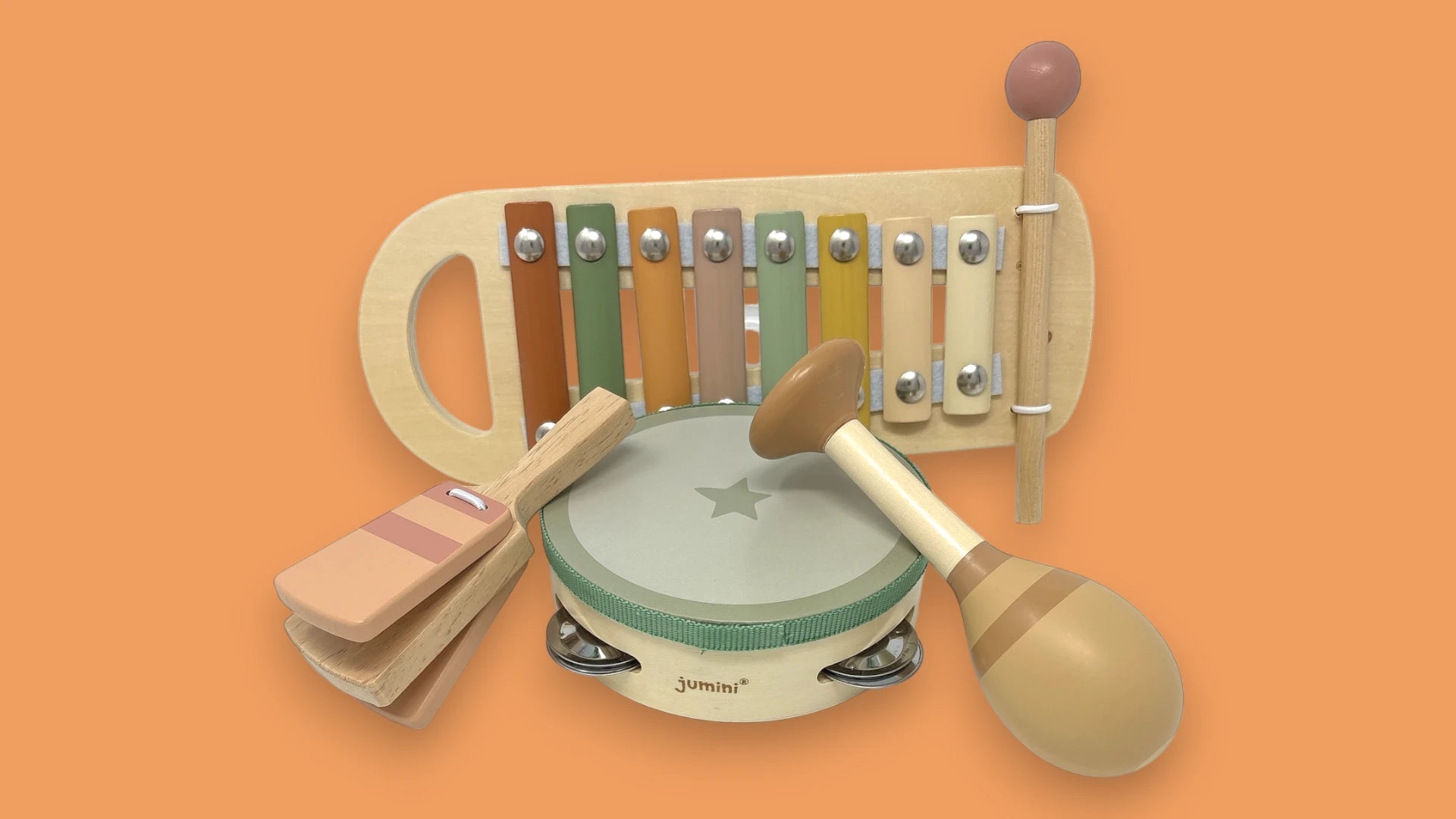 A wooden toy music set on a solid orange background, featuring a xylophone, tambourine, maracas, and claps. The toys are made of natural light wood with colourful painted keys and accessories.
