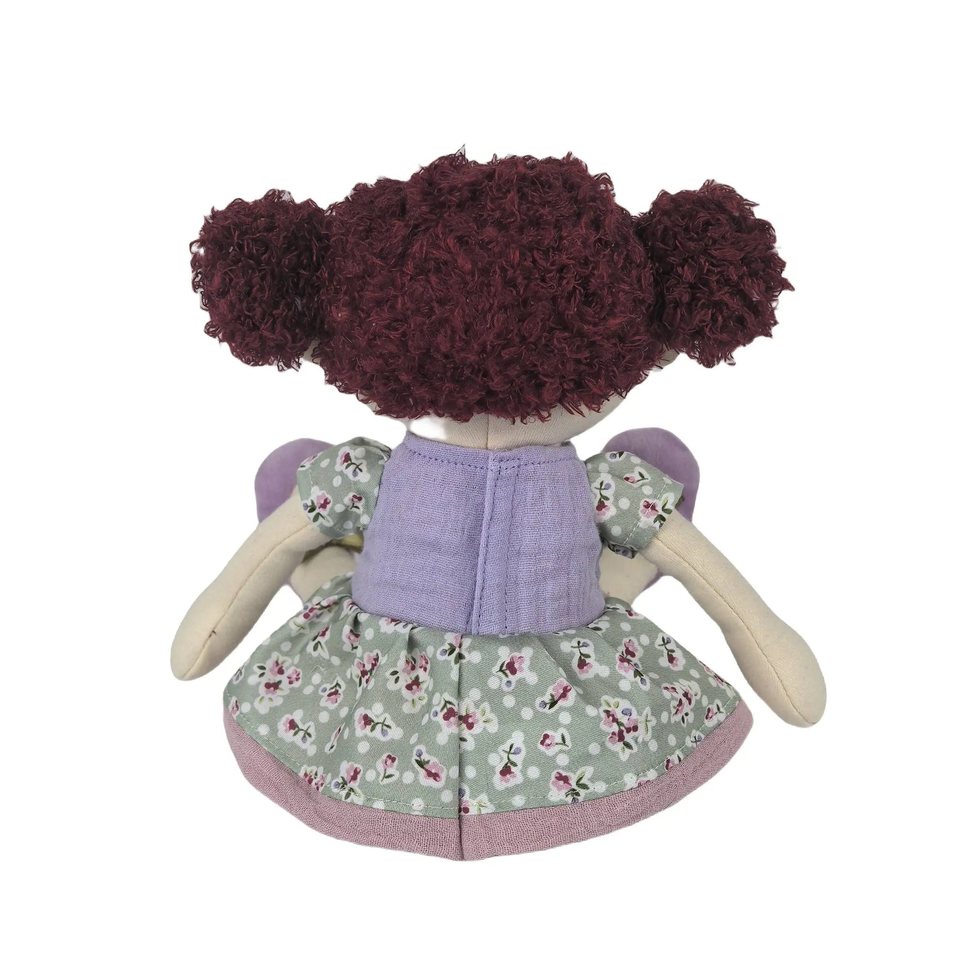 Toy doll with curly hair wearing a floral dress on a white background