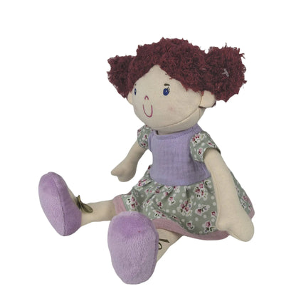 Plush doll with red hair, purple outfit, and floral dress on a white background