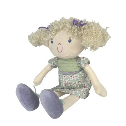 Toy doll with blonde hair, green dress, and purple shoes on a white background