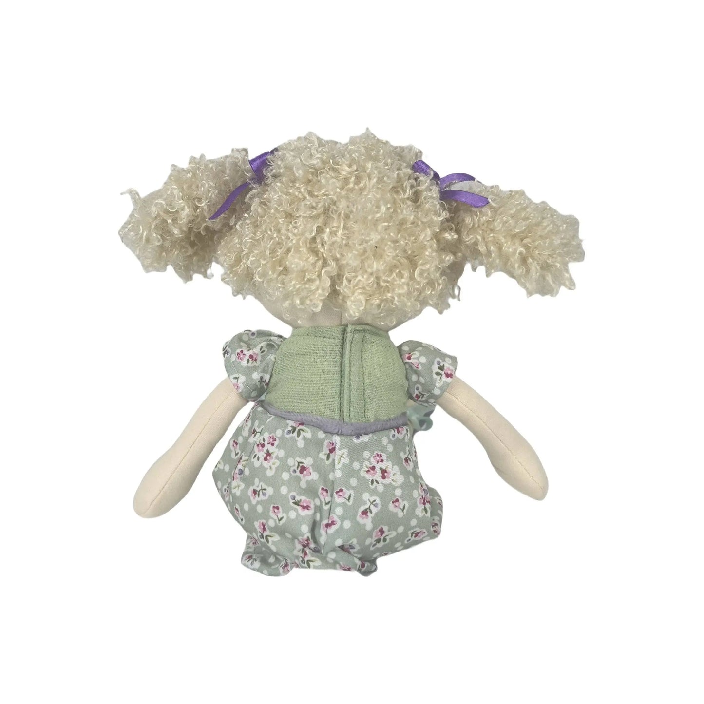 Toy doll with curly hair and a floral dress on a white background